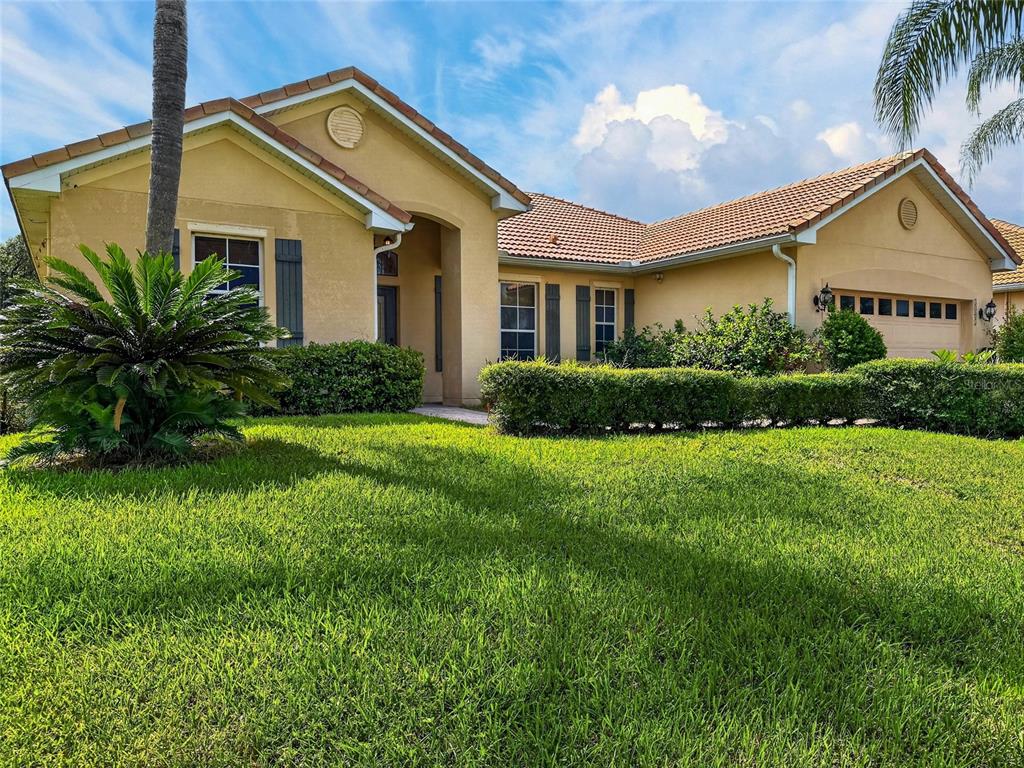 A single-story tan house with a tile roof, a two-car garage, and a landscaped front yard — 3505 FOREST PARK DRIVE, KISSIMMEE, FL