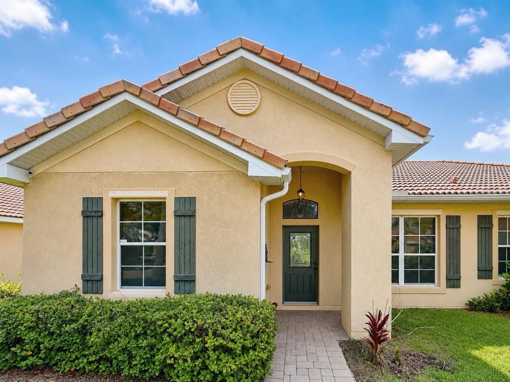 A single-story house with a beige stucco exterior, tile roof, and a dark green front door — 3505 FOREST PARK DRIVE, KISSIMMEE, FL