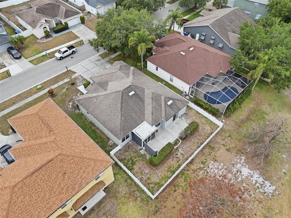 An aerial view shows a residential house with a gray roof and a fenced backyard — 11214 SAILBROOKE DRIVE, RIVERVIEW, FL