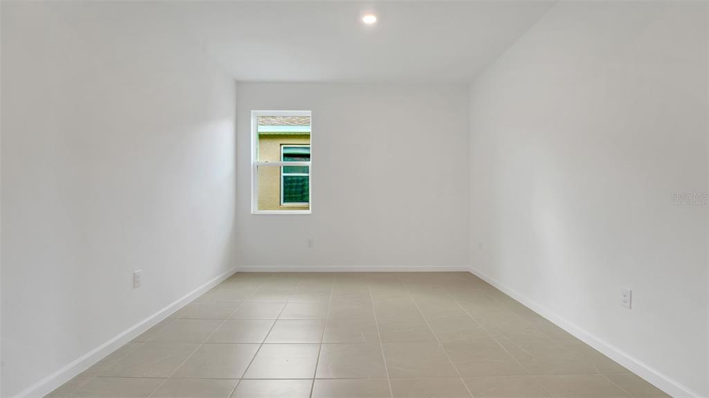 An empty room features white walls, light-colored tile flooring, and a single window — 4094 PENELOPE AVENUE, LAKE WALES, FL