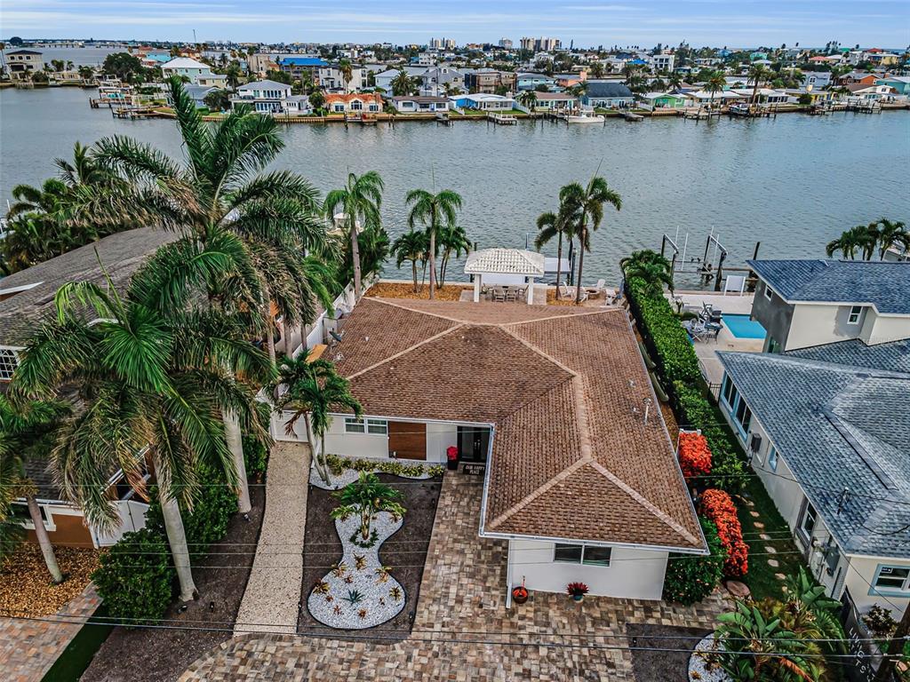 An aerial view shows a waterfront house with a tiled roof, palm trees, and landscaping — 16353 REDINGTON DRIVE, REDINGTON BEACH, FL