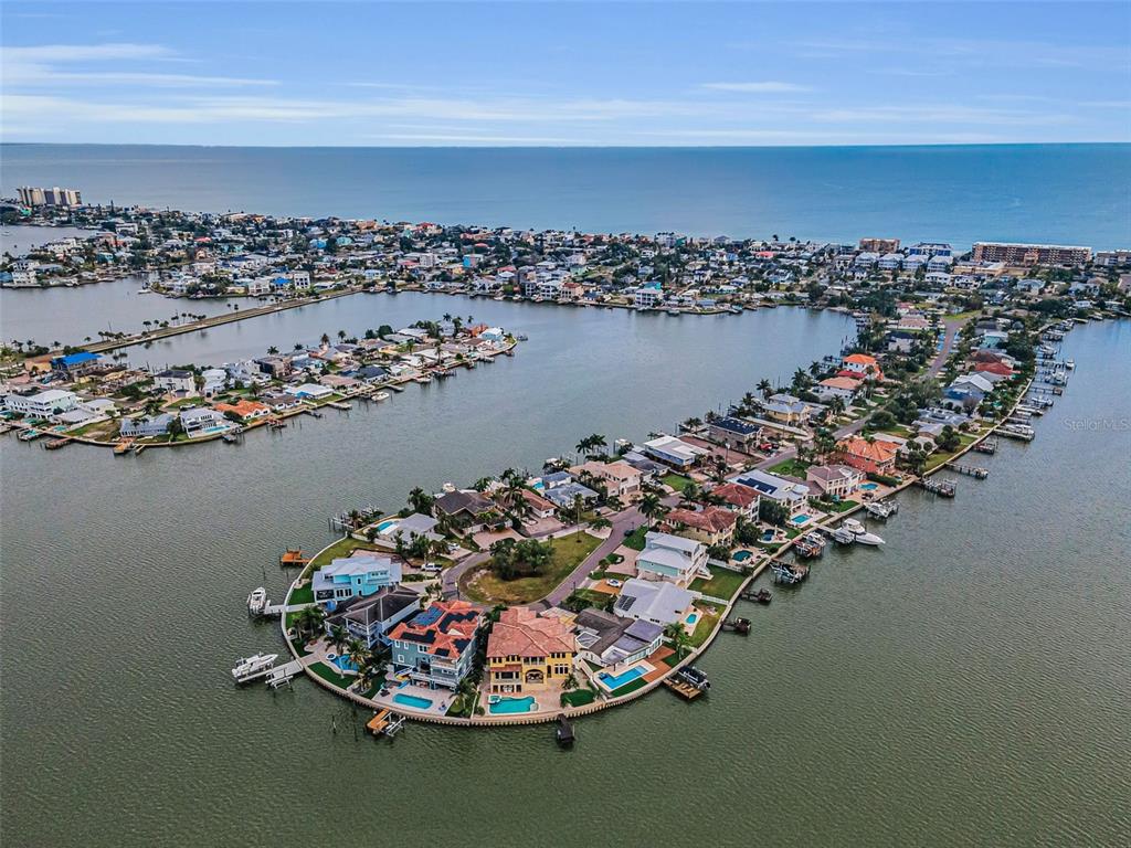 An aerial view shows waterfront homes on a peninsula surrounded by a bay and ocean — 16353 REDINGTON DRIVE, REDINGTON BEACH, FL
