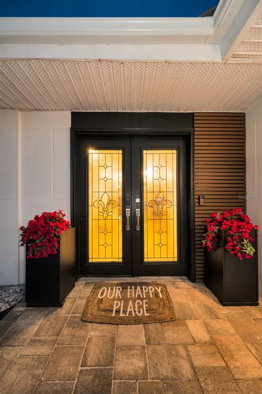 A front entryway features double doors with decorative glass, two large planters, and a doormat — 16353 REDINGTON DRIVE, REDINGTON BEACH, FL