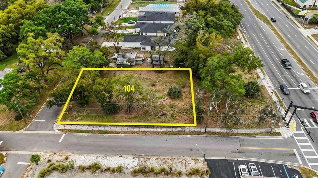 An aerial view shows a vacant, rectangular lot outlined in yellow near a busy road — 104 N VAN BUREN AVENUE, ORLANDO, FL