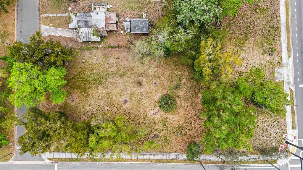 An aerial view shows a vacant lot with trees and a small, weathered structure — 104 N VAN BUREN AVENUE, ORLANDO, FL