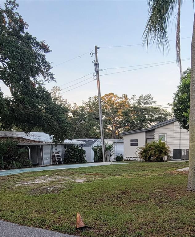 A view of a grassy yard with a utility pole and several single-story residential buildings — 585 SKY HARBOR DRIVE UNIT 126, CLEARWATER, FL