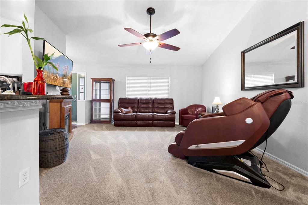 A living room features a massage chair, a leather sofa, and a ceiling fan — 11244 REDGATE STREET, SPRING HILL, FL
