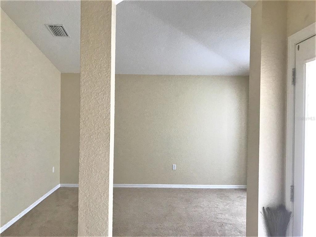 A view through a doorway into a carpeted room with beige walls and a ceiling vent — 3480 HAWKIN DRIVE, KISSIMMEE, FL