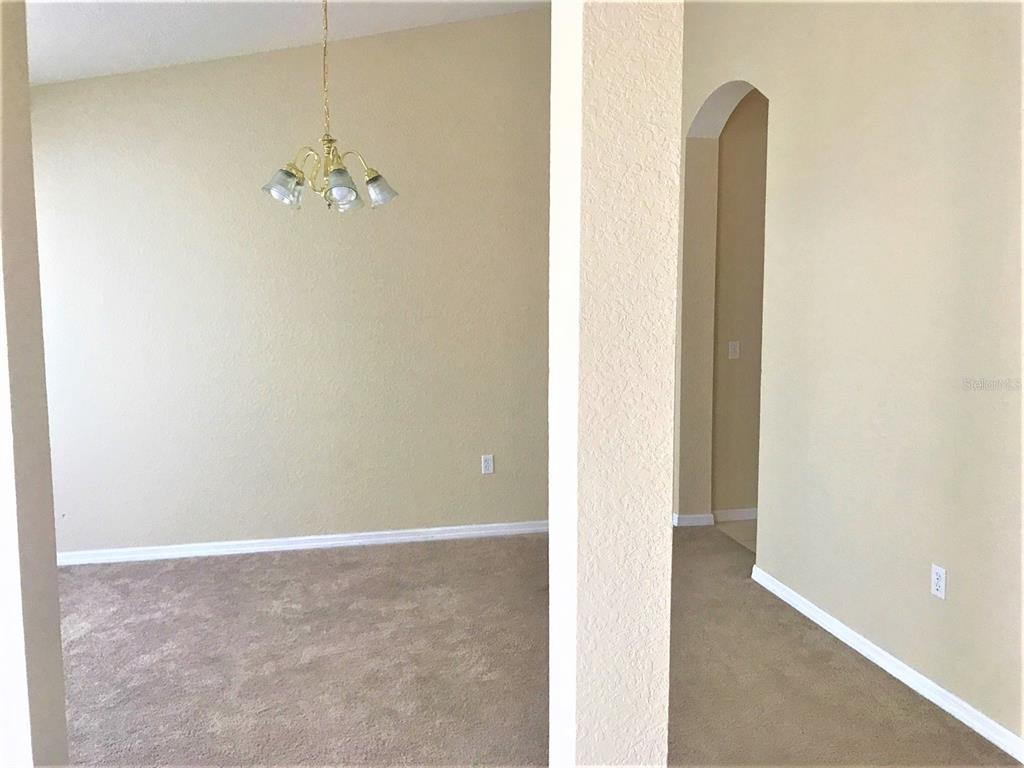 A dining area with a chandelier and carpeted floors is visible through a wide doorway — 3480 HAWKIN DRIVE, KISSIMMEE, FL
