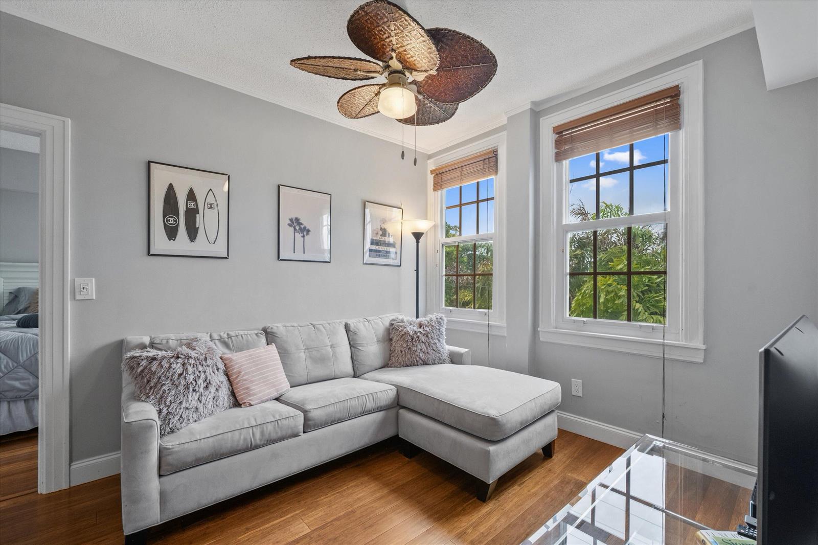 A living room features a gray sectional sofa, a palm-leaf ceiling fan, and two windows — 235 Sunrise Avenue # 3232, Palm Beach FL 33480, PALM BEACH, FL