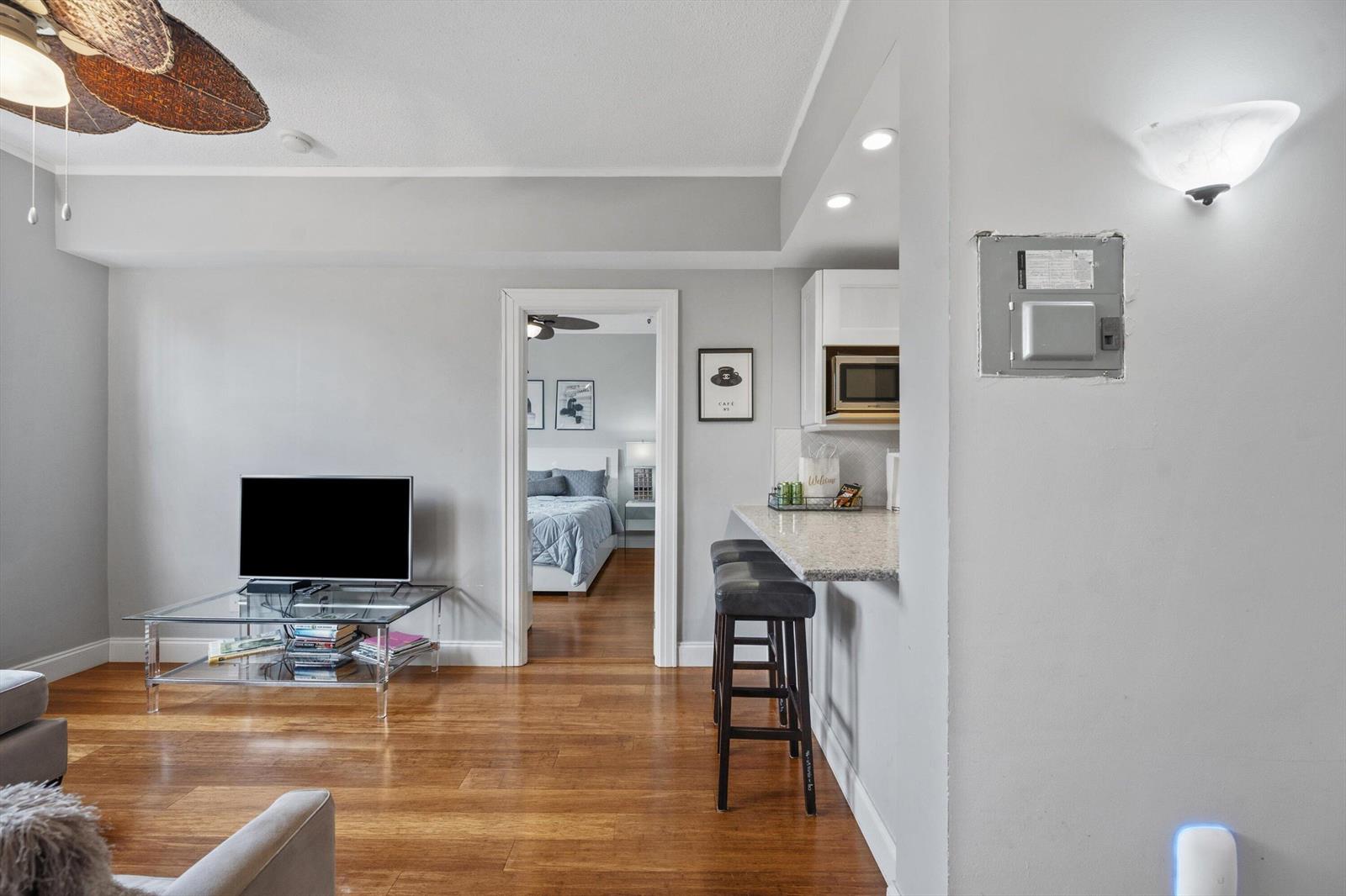 A living room with hardwood floors, a glass coffee table, and a breakfast bar area — 235 Sunrise Avenue # 3232, Palm Beach FL 33480, PALM BEACH, FL