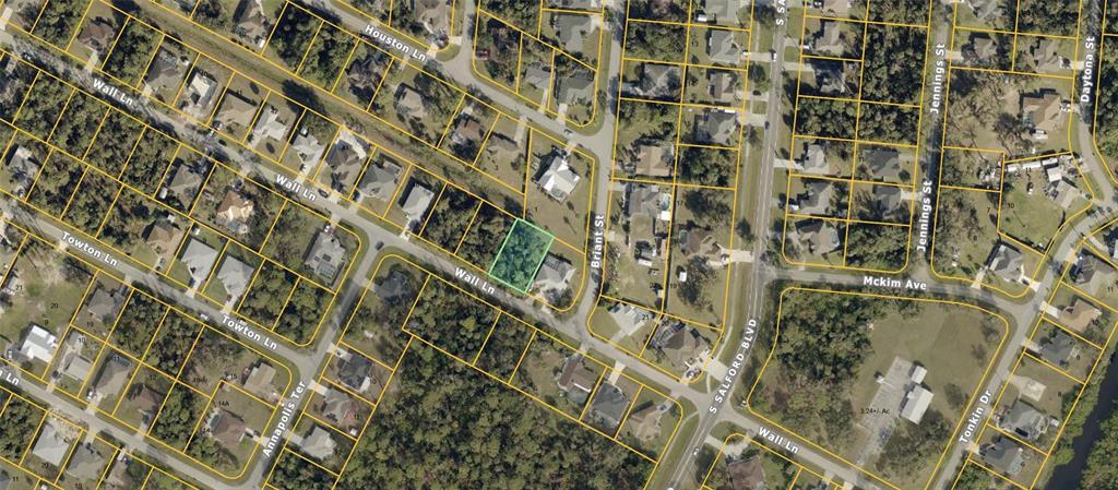 This is an aerial map view showing a highlighted vacant lot in a residential neighborhood — WALL LANE, NORTH PORT, FL