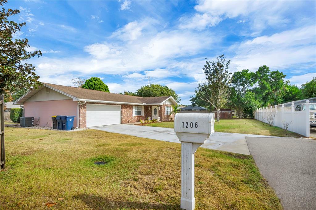 A single-story house with a brick facade, a two-car garage, and a mailbox in front — 1206 SUSAN LANE, AUBURNDALE, FL