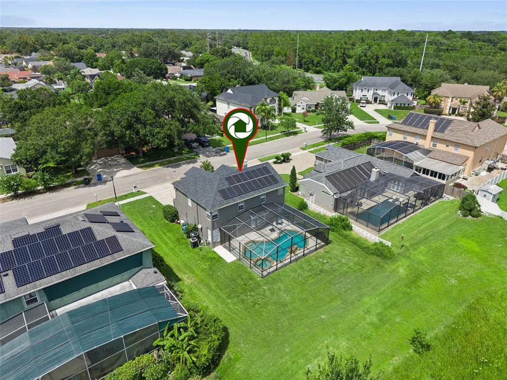 An aerial view of a two-story house with a pool enclosure and rooftop solar panels — 2743 RUNNING SPRINGS LOOP, OVIEDO, FL