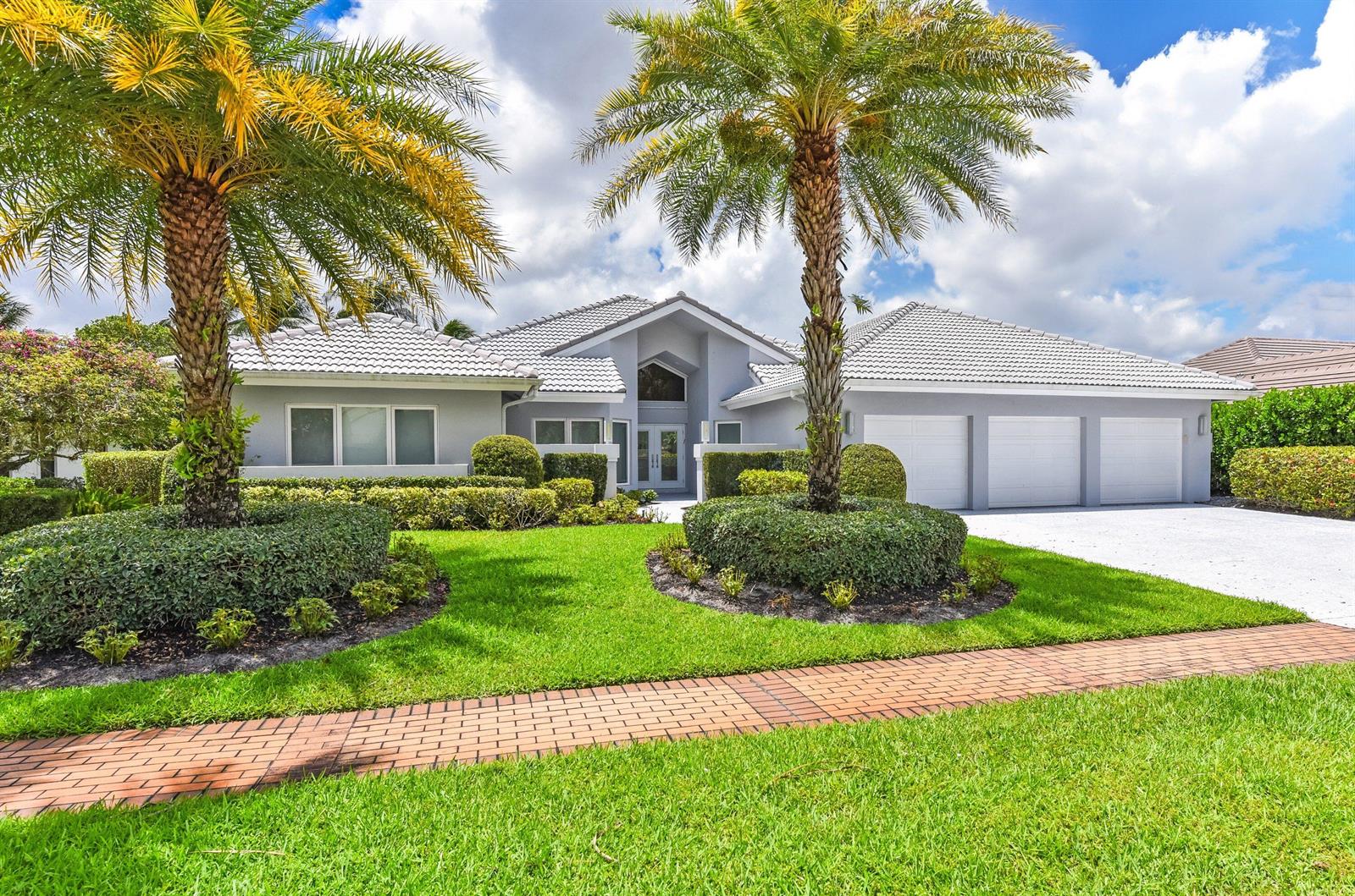 A single-story gray house with a three-car garage and two palm trees in the front yard — 17771 Foxborough Lane, Boca Raton FL 33496, BOCA RATON, FL