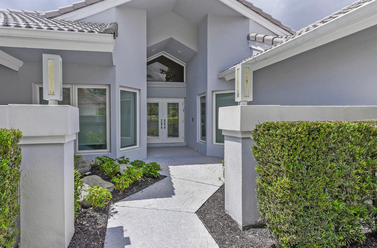A paved walkway leads to the double front doors of a light gray stucco house — 17771 Foxborough Lane, Boca Raton FL 33496, BOCA RATON, FL