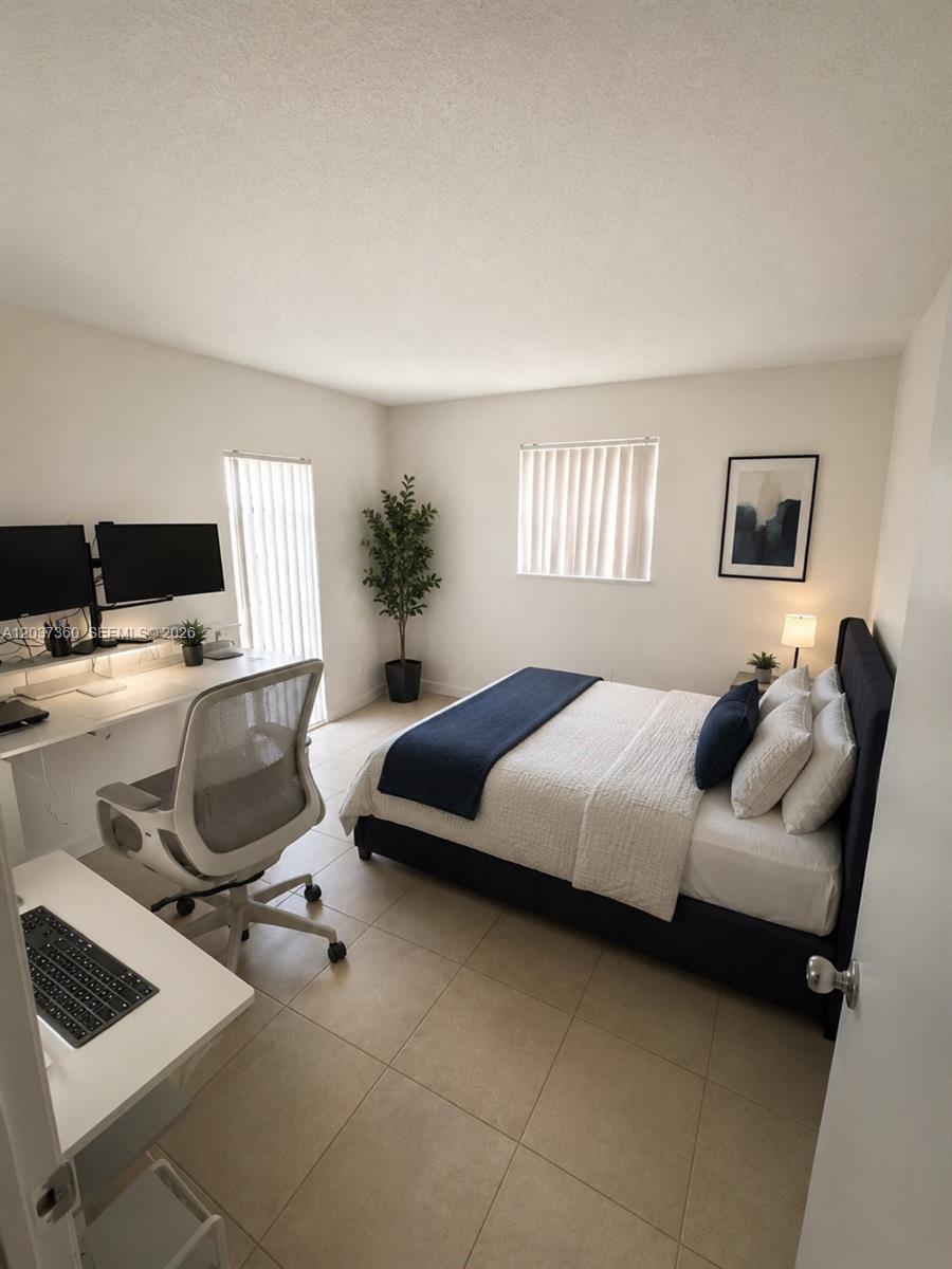 A bedroom features a bed, a desk with dual monitors, and tile flooring — 8650 SW 109th Ave # 103, Miami FL 33173, MIAMI, FL