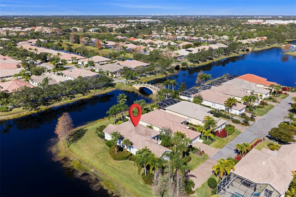 An aerial view shows a house with a red location pin beside a lake — 5735 WILENA PLACE, SARASOTA, FL