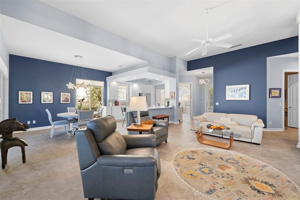 A living room and dining area feature blue accent walls, tile flooring, and white cabinetry — 5735 WILENA PLACE, SARASOTA, FL