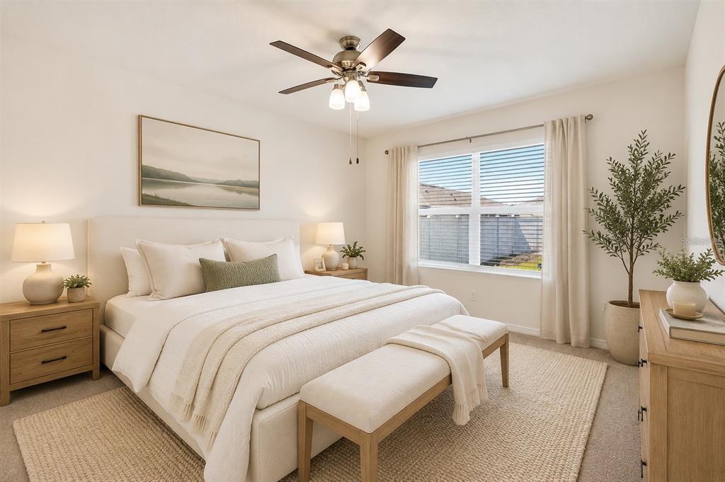 A neutral-toned bedroom features a king bed, wooden nightstands, a ceiling fan, and a window — 1673 BARBERRY DRIVE, KISSIMMEE, FL