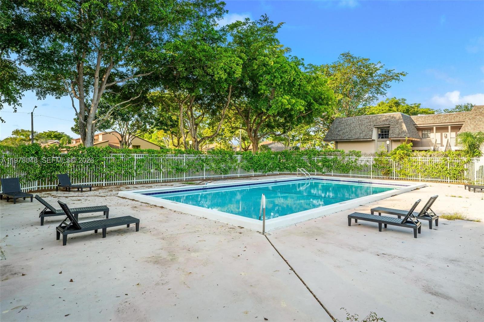 A rectangular swimming pool is surrounded by a concrete deck, lounge chairs, and privacy fencing — 3631 NW 94th Ave # 6G, Sunrise FL 33351, SUNRISE, FL