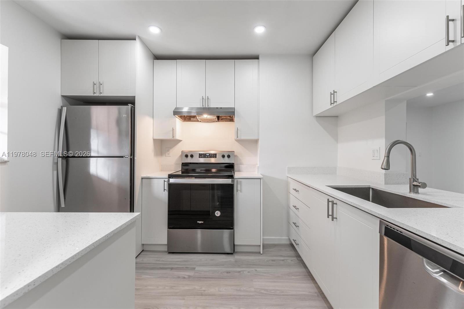 A modern kitchen features white cabinets, stainless steel appliances, and light-colored quartz countertops — 3631 NW 94th Ave # 6G, Sunrise FL 33351, SUNRISE, FL