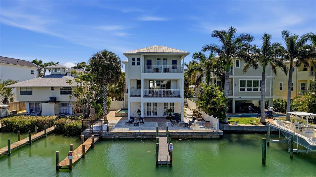A three-story waterfront house with balconies and a private dock sits along a canal — 418 PINE AVENUE, ANNA MARIA, FL
