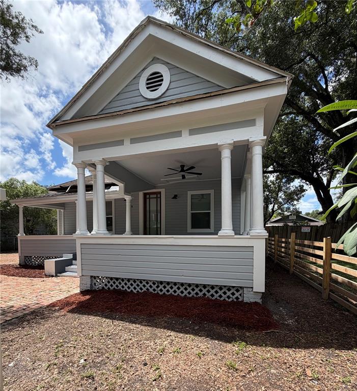 A light gray house features a covered front porch with white columns and lattice skirting — 919 E 26TH AVENUE, TAMPA, FL