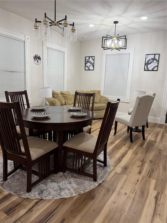 A dining area features a round wooden table, dark chairs, and two modern light fixtures — 919 E 26TH AVENUE, TAMPA, FL
