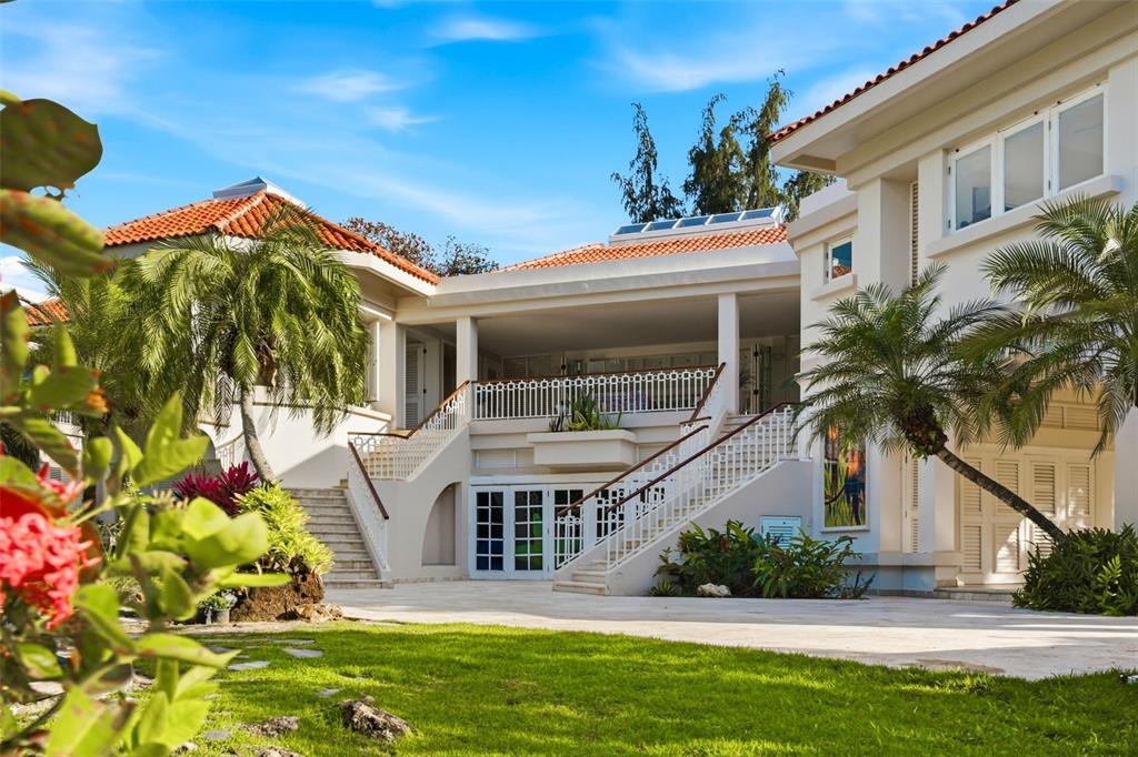 A two-story house with a tiled roof, dual staircases, and a paved courtyard — 15 DORADO BEACH ESTATES, DORADO, PR