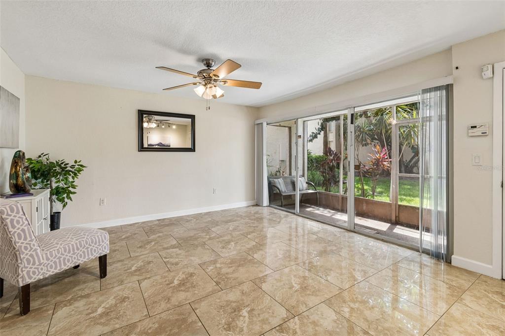 A dining room with tile flooring, a ceiling fan, and sliding glass doors to a patio — 3841 S LAKE DRIVE UNIT 197, TAMPA, FL