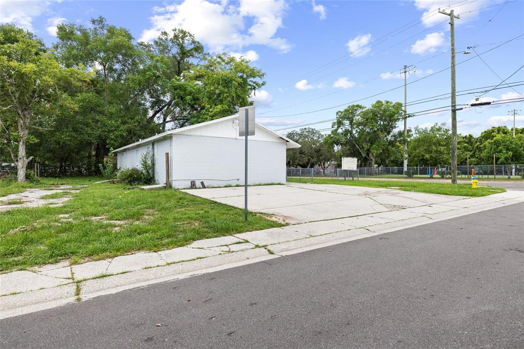 A white, single-story building sits on a corner lot with a concrete driveway — 3713 N 34TH STREET, TAMPA, FL