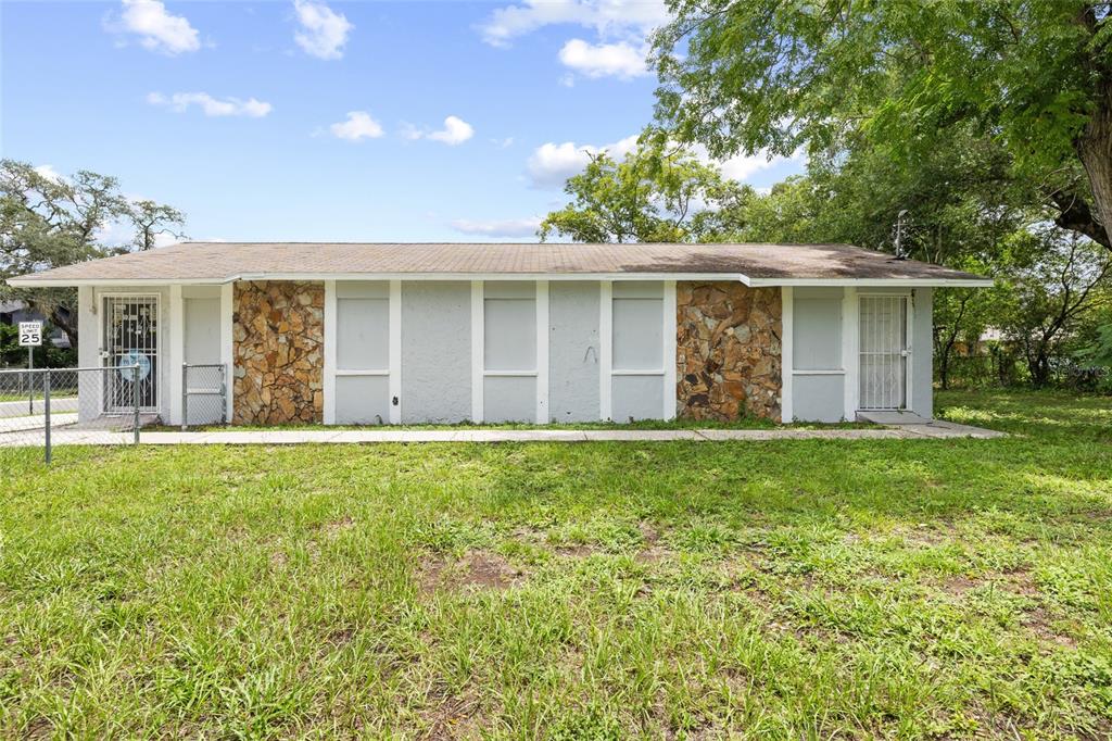 A single-story building features a stone and light-colored facade with multiple doors and windows — 3713 N 34TH STREET, TAMPA, FL