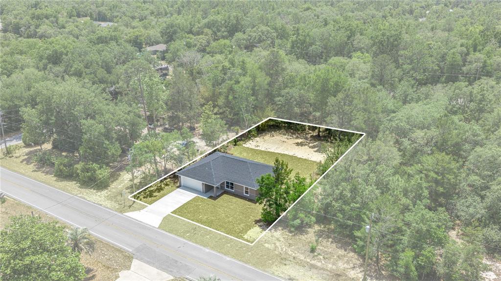 An aerial view shows a single-story house with a driveway on a wooded lot — 22930 SW MARINE BOULEVARD, DUNNELLON, FL