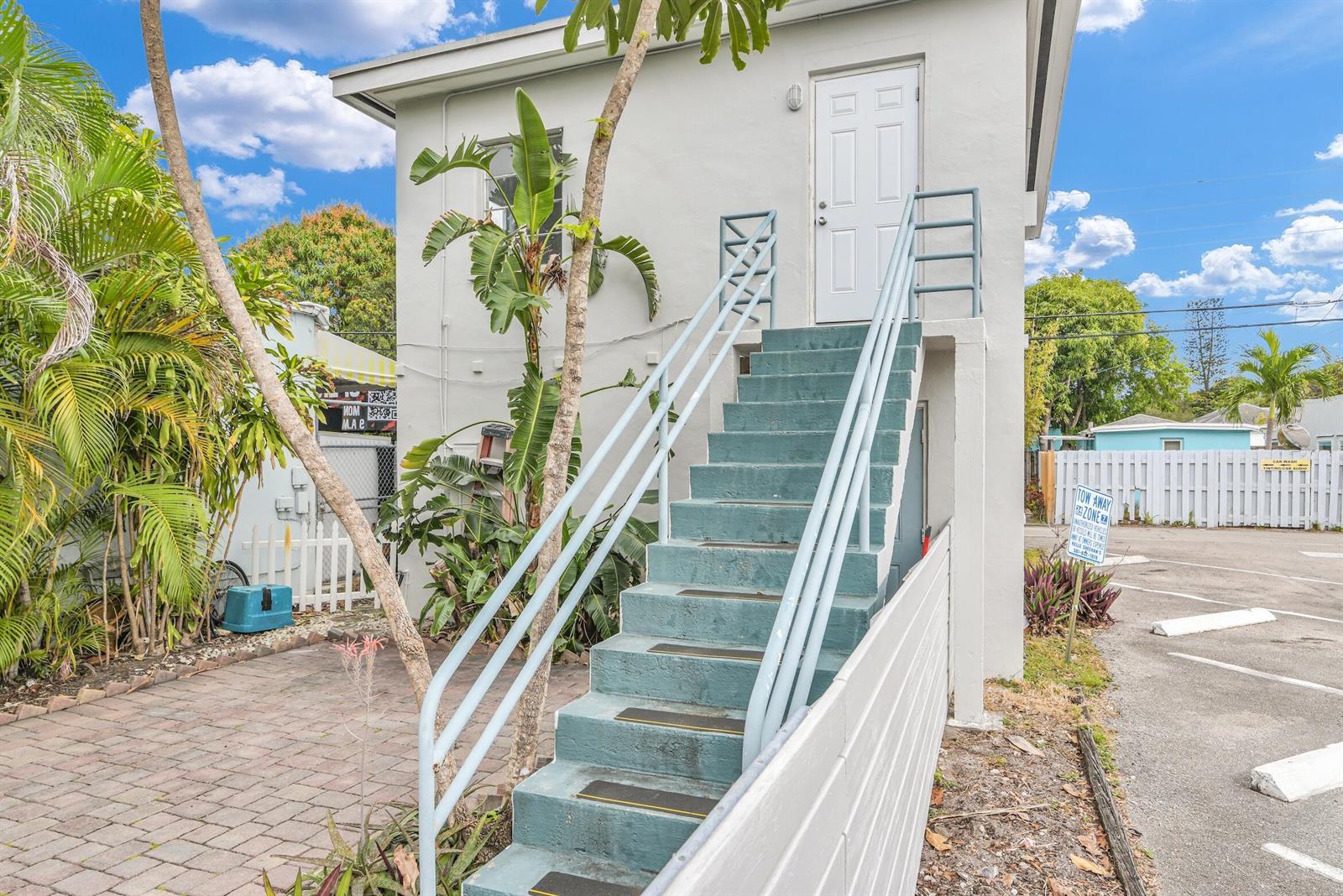 An exterior view of a two-story building featuring an outdoor staircase leading to an upper door — 820 N Dixie Highway # 4, FL 33460, FL