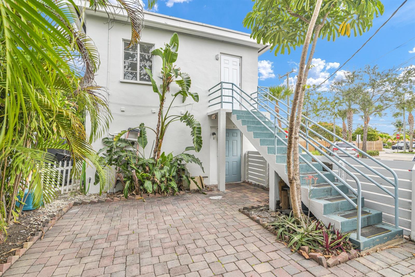 A two-story white building features an exterior staircase leading to an upper-level door — 820 N Dixie Highway # 4, FL 33460, FL
