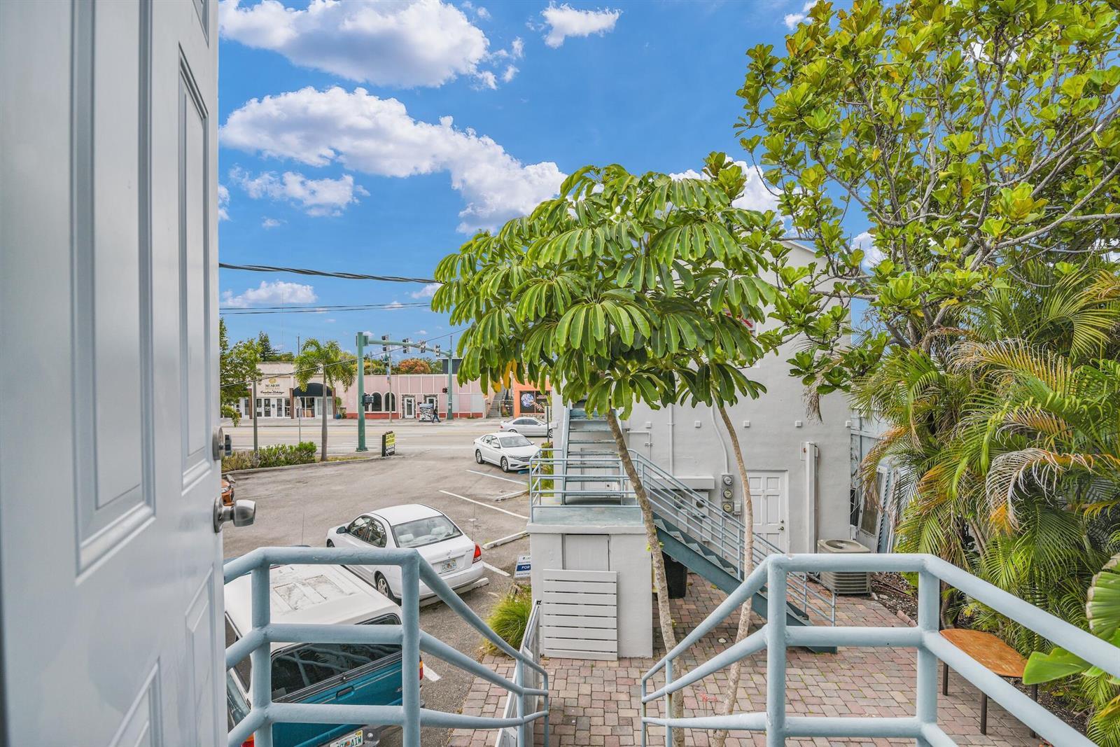 An exterior view from a doorway looking down a staircase toward a parking lot — 820 N Dixie Highway # 4, FL 33460, FL