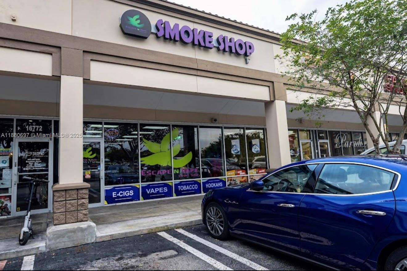 The exterior of a retail smoke shop storefront features large glass windows and a blue car — 16774 SW 88TH ST, Miami FL 33196, MIAMI, FL