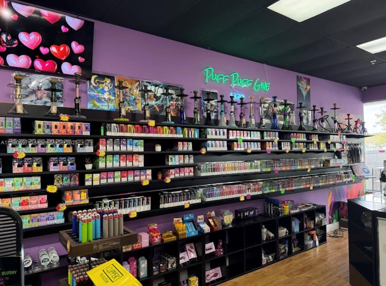 A retail store interior features purple walls, black shelving stocked with vaping products, and hookah displays — 16774 SW 88TH ST, Miami FL 33196, MIAMI, FL