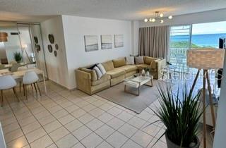 A living room with a beige sectional sofa, a coffee table, and ocean views — 4837 AVE. ISLA VERDE UNIT 209, CAROLINA, PR
