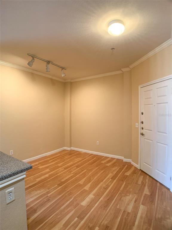 An empty room features light wood flooring, beige walls, a ceiling light, and track lighting — 860 N ORANGE AVENUE UNIT 428, ORLANDO, FL