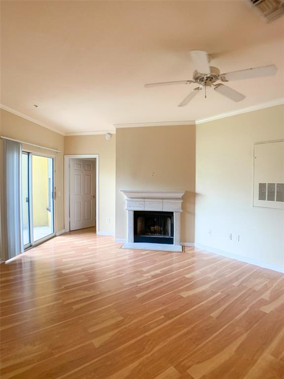A living room with light wood flooring, a central fireplace, and a ceiling fan — 860 N ORANGE AVENUE UNIT 428, ORLANDO, FL
