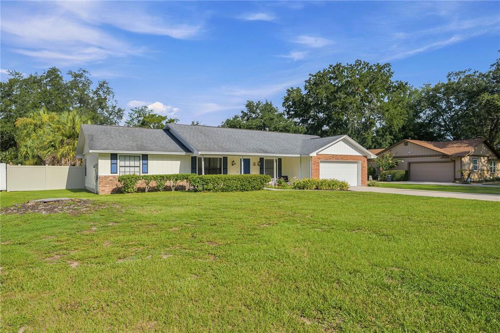 A single-story house with a brick-accented garage and a large front lawn — 1522 SE 43RD AVENUE, OCALA, FL