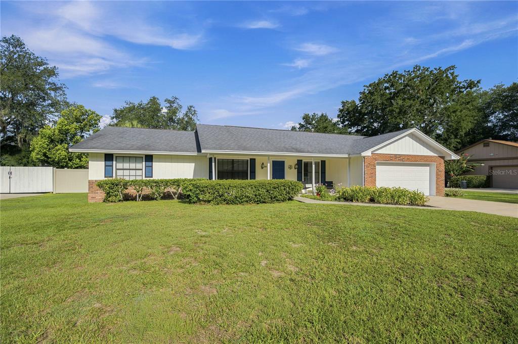 A single-story house with a white exterior, brick accents, and a two-car garage — 1522 SE 43RD AVENUE, OCALA, FL