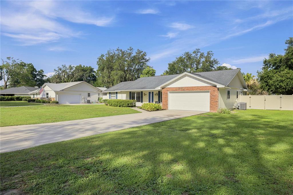 A single-story house with a brick-accented garage and a long concrete driveway — 1522 SE 43RD AVENUE, OCALA, FL