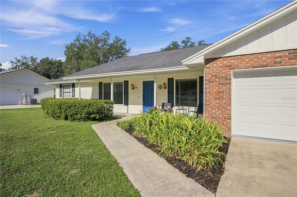 A single-story house with a brick facade, blue front door, and a concrete walkway — 1522 SE 43RD AVENUE, OCALA, FL