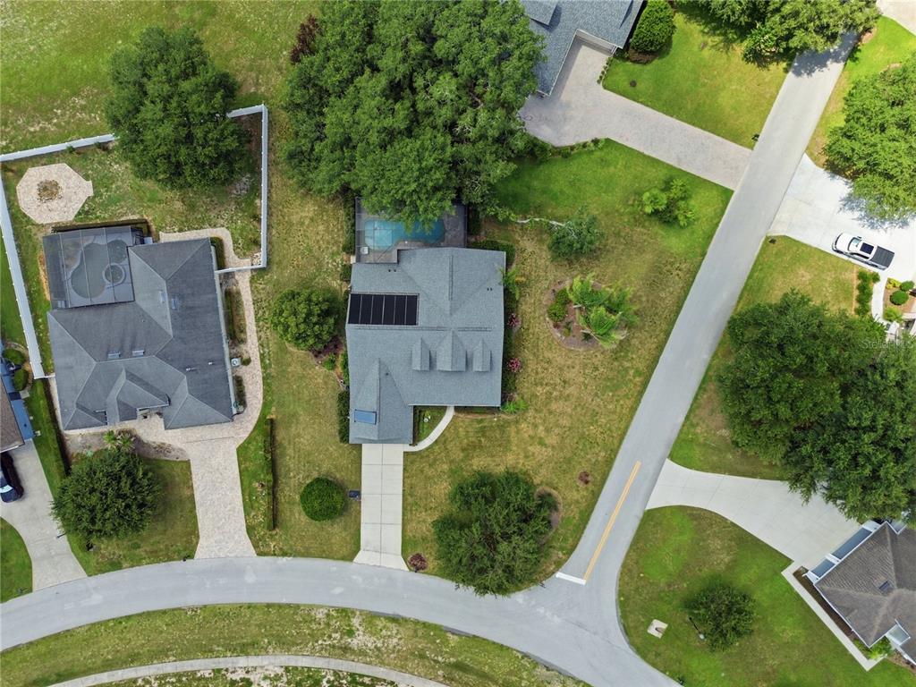 An aerial view shows a residential house with a pool, solar panels, and surrounding landscaping — 23354 OAK PRAIRIE CIRCLE, SORRENTO, FL