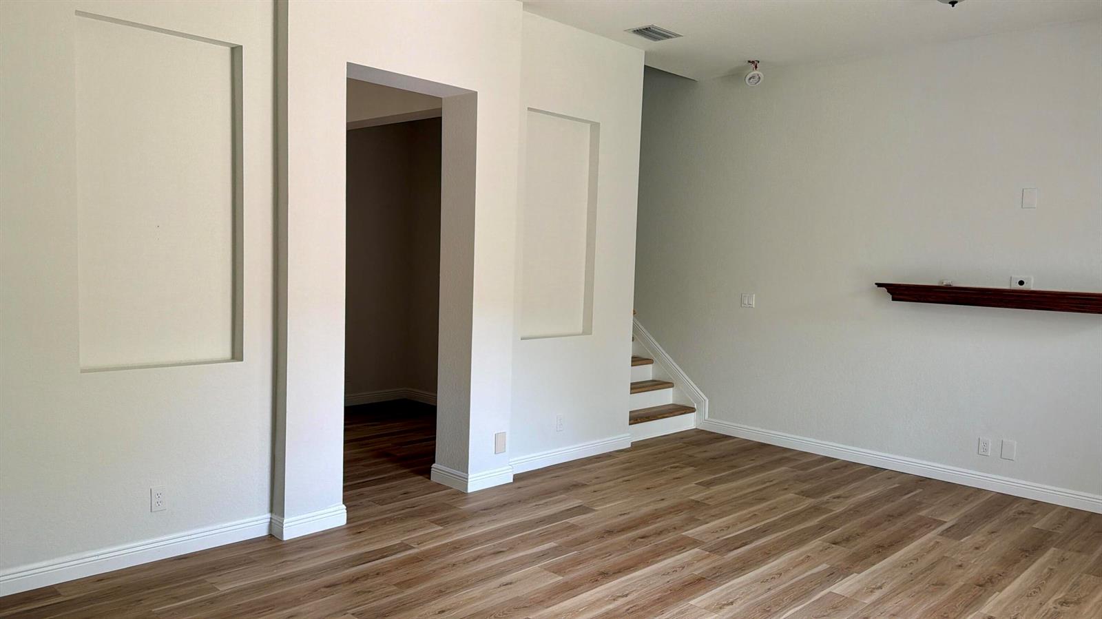 An interior view shows a living area with wood-look flooring, recessed wall niches, and stairs — 814 NW 82nd Place, Boca Raton FL 33487, BOCA RATON, FL