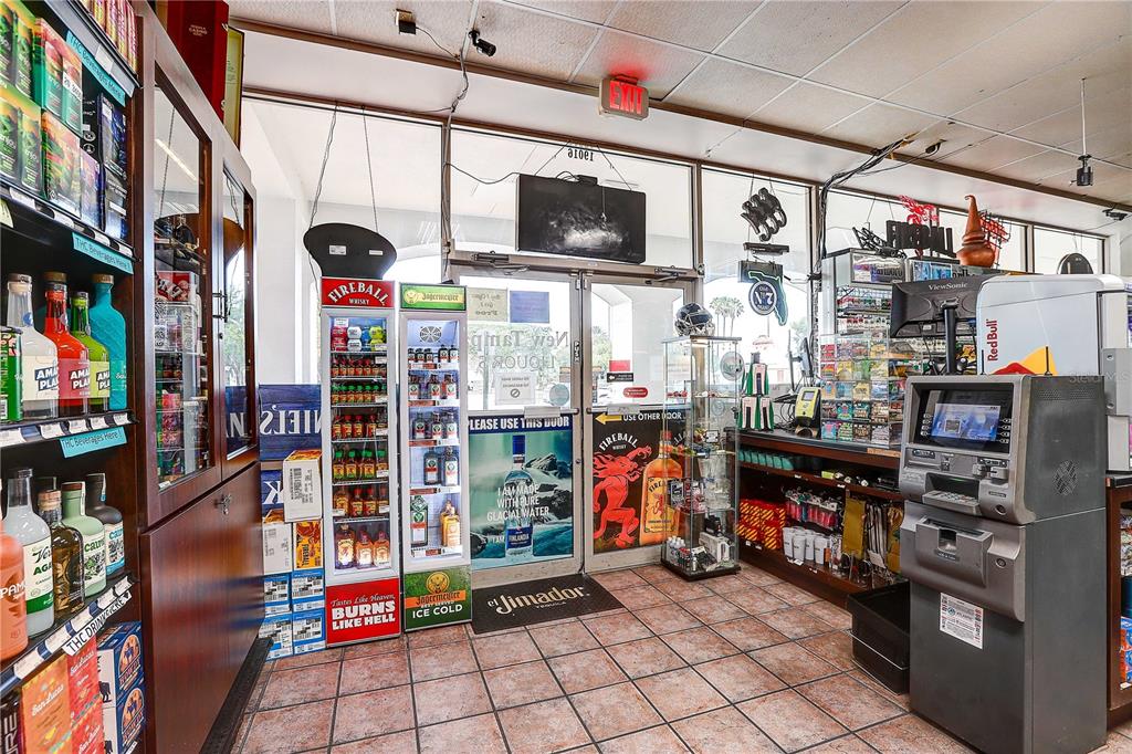 The interior of a liquor store features tiled floors, glass display cases, and beverage refrigerators — BRUCE B DOWNS BOULEVARD, TAMPA, FL