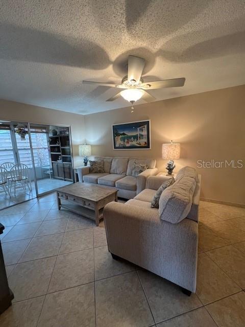 A living room features a beige sofa, a wooden coffee table, and a ceiling fan — 2666 WOODGATE LANE UNIT D-1, SARASOTA, FL